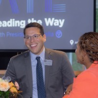 GVSU employee smiles at table with woman